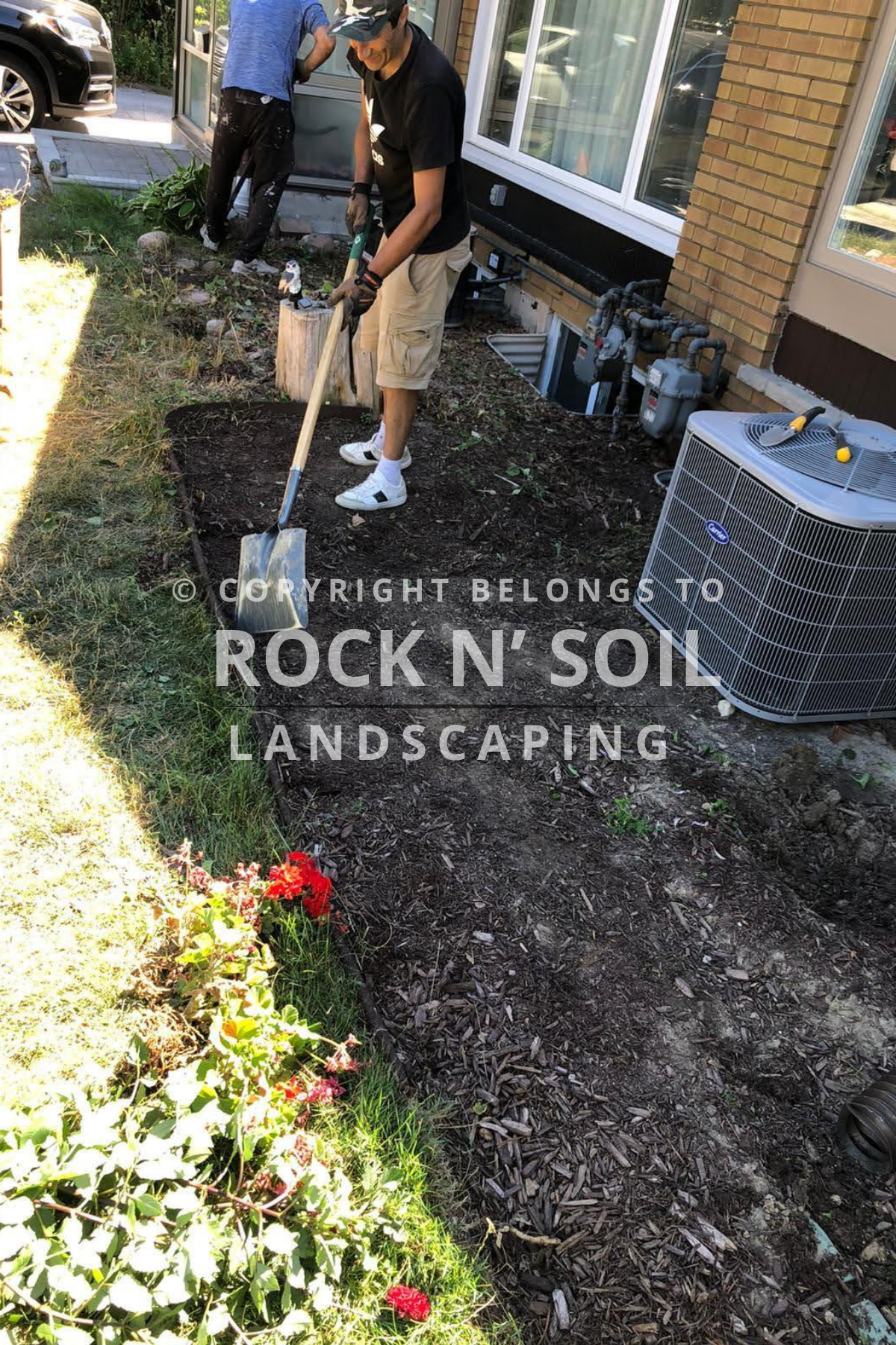 New flower bed preparation with soil for gardening, adjacent to a residential home