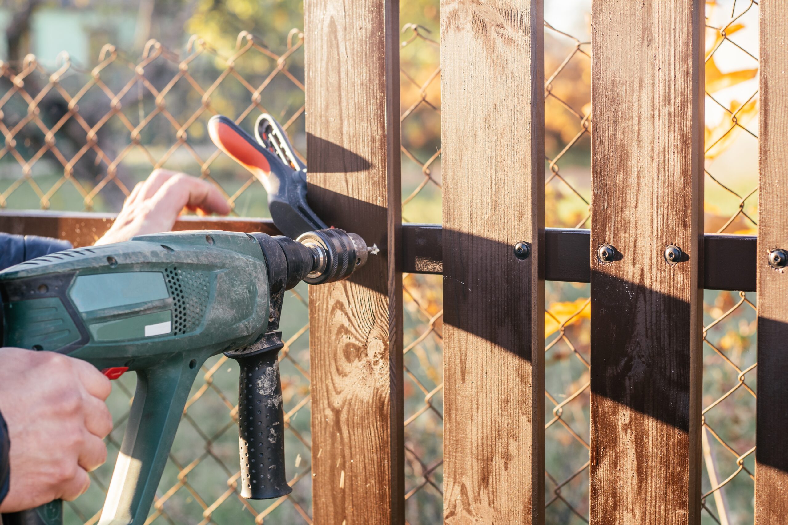 Drilling into a wooden fence during installation