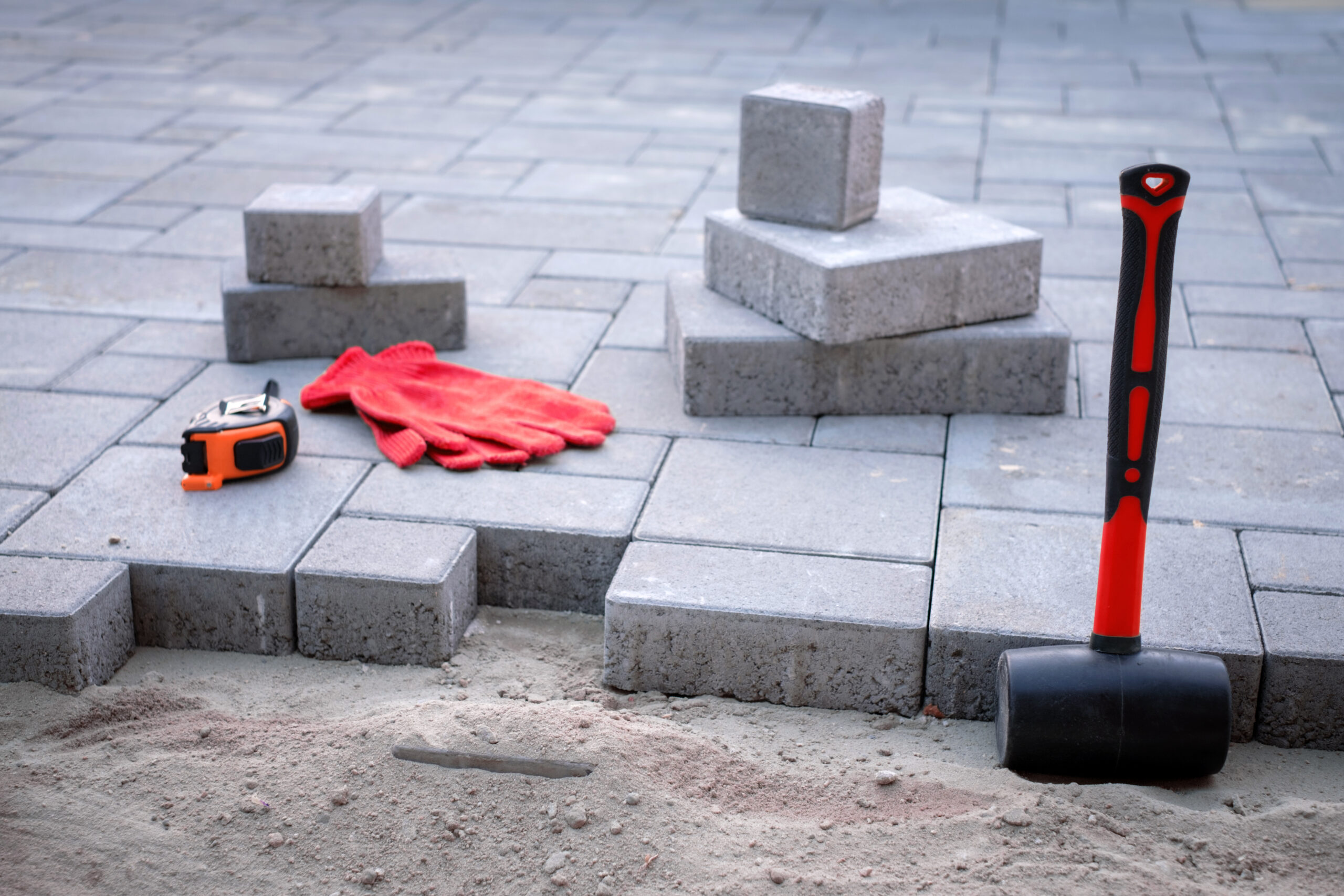 Hands aligning interlocking bricks during the installation process