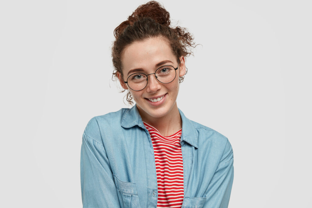 A woman smiling warmly, ready to answer important questions about landscaping services.