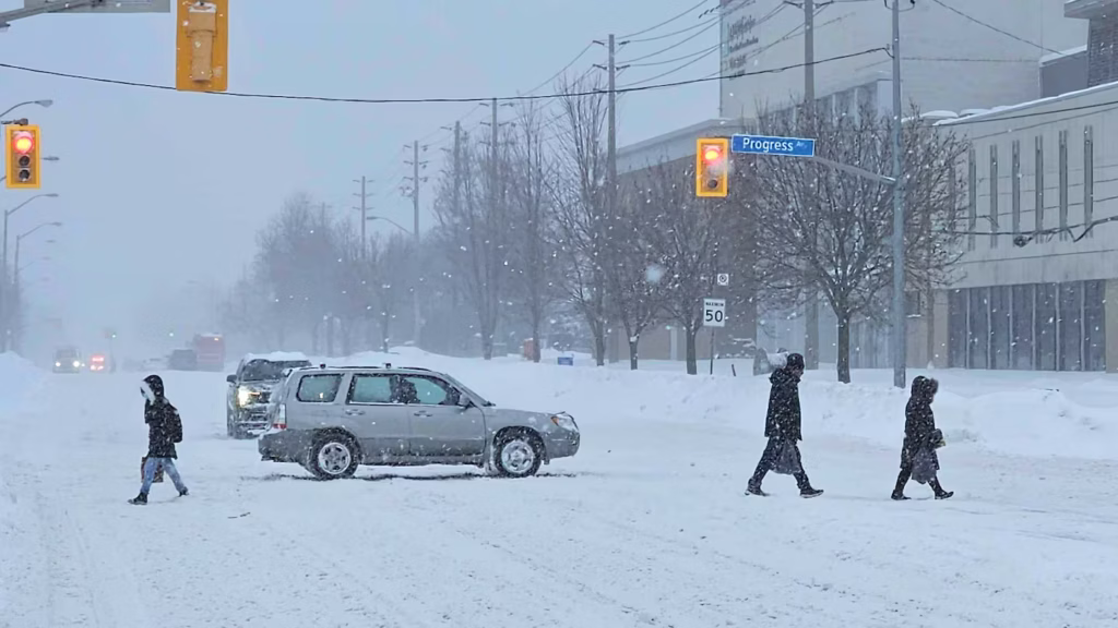 Toronto covered in deep snow after a heavy snowfall, with a snow removal crew actively clearing it.