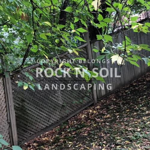 Old, unattractive fence before installation of a new fence